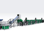 een uitgebreide plastic recyclinglijn die is ontworpen voor het versnipperen en verdichten van PP/PE-folies. Deze opstelling omvat verschillende onderling verbonden modules zoals transportbanden, versnipperaars, wasstations en verdichters, allemaal voornamelijk in de kleuren groen en grijs. Dergelijke systemen zijn essentieel voor het verwerken van plastic folies, waarbij ze van afval worden omgezet in herbruikbare materialen via een reeks mechanische en chemische processen. De lay-out is georganiseerd om de materiaalstroom te optimaliseren van de eerste versnipperingsfasen tot de uiteindelijke verdichting, waardoor efficiënte recyclingbewerkingen worden gegarandeerd.