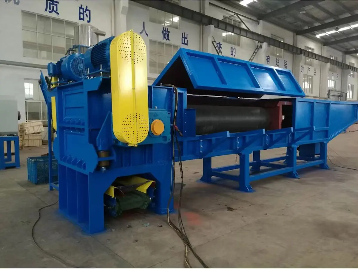 L'image présente un déchiqueteur de tuyaux en PEHD (polyéthylène haute densité). Cet équipement industriel est peint en bleu vif et comprend des capots de sécurité jaunes. Il est spécialement conçu pour le broyage de gros tuyaux en PEHD, couramment utilisés dans les réseaux de distribution d'eau et de gaz. Le broyeur comprend un mécanisme de coupe robuste, évident grâce au grand composant cylindrique à l'intérieur du boîtier. Les commandes et les fonctions de sécurité sont visibles, ce qui suggère qu'il est conçu pour un fonctionnement intensif et la sécurité des utilisateurs. La structure supportant le broyeur assure la stabilité pendant le processus de broyage intense, ce qui en fait un outil essentiel pour recycler et gérer efficacement les déchets de PEHD.