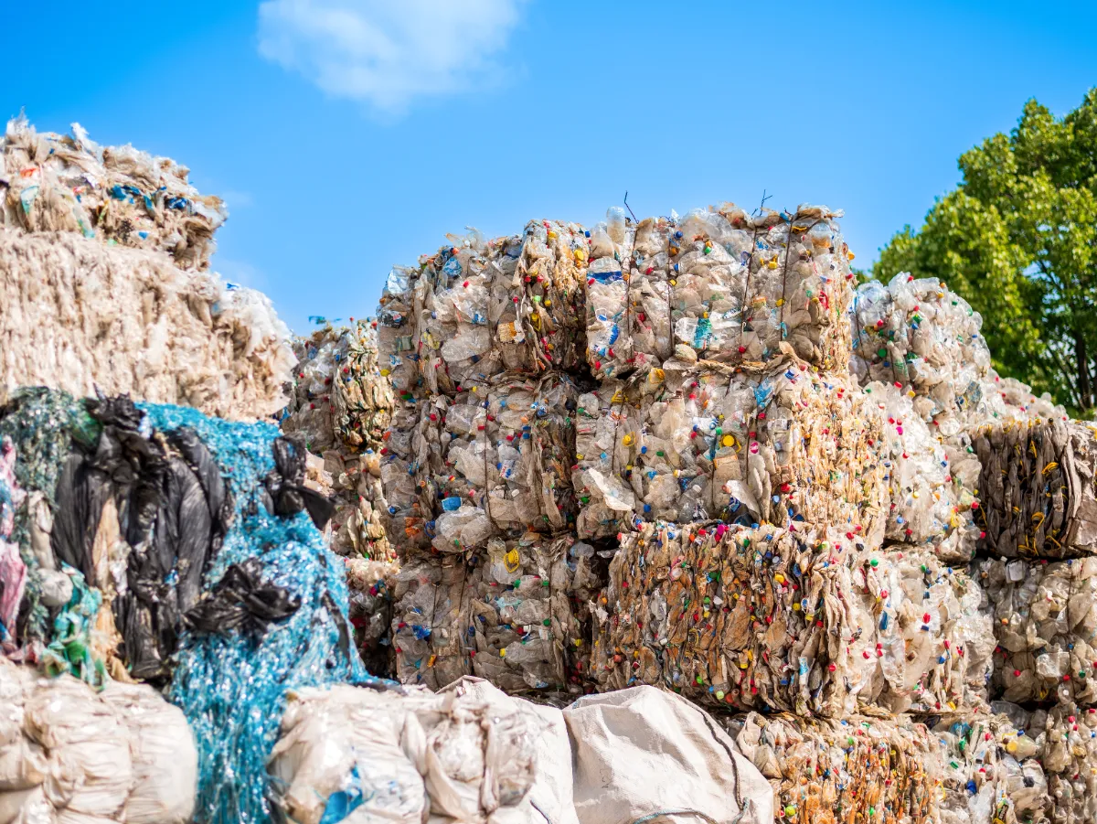 large bales of compressed plastic waste, which are typically prepared for recycling. These bales are formed after the sorting and cleaning processes, where different types of plastics are compressed into manageable blocks for easier transport and further processing. The variety of colors within each bale indicates a mix of different plastic items, which suggests that these bales may be destined for a facility that will further sort and recycle the material into new plastic products. This is a common practice in the recycling industry to reduce the volume of waste, making it more cost-effective to transport materials to recycling plants. Recycling facilities often use balers to compact the sorted recyclable materials into dense, tied bales. The bales conserve space during storage and transport, and their uniform shape makes them easier to handle and process