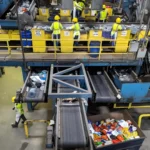 Geri dönüşüm tesisindeki işçiler geri dönüştürülmüş plastiği ayırıp ayırıyor