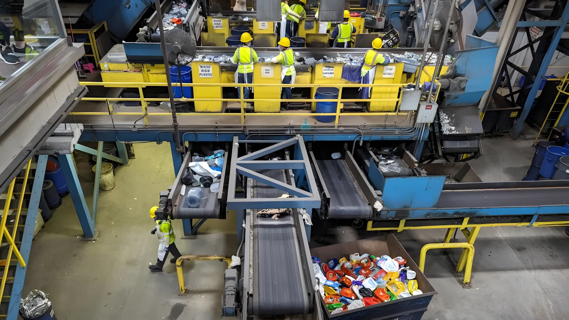 Workers at a recycling facility sort and separate recycled plasti